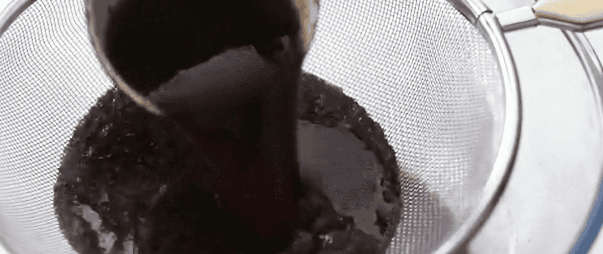 Straining broth through a colander.