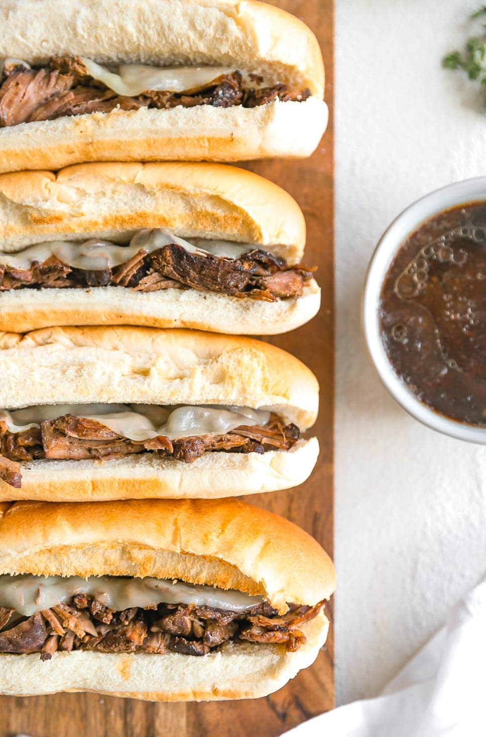 french dip sandwiches in a row with beef au jus dipping sauce