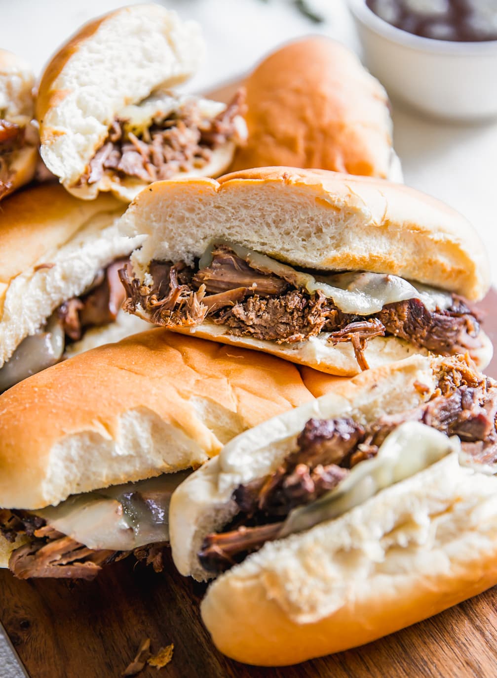 French Dip Sandwich, or French Dip Au Jus, is a delicious and easy way to enjoy crockpot beef! We create a Beef Au Jus sandwich with tender beef, provolone cheese, toasty bread, and of course the dipping sauce. Such a simple crockpot french dip recipe that the entire family will love. This French Dip Sandwich Recipe is a winner! slow cooker french dip sandwiches with provolone cheese