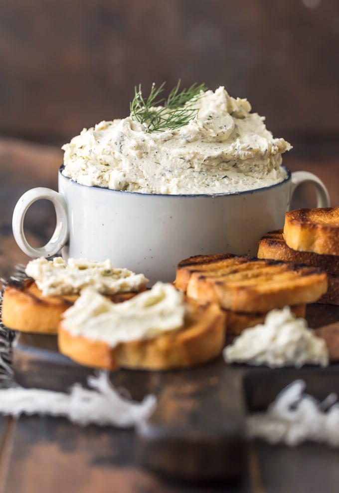 Stacked toasted bread surrounding a bowl of Boursin cheese.