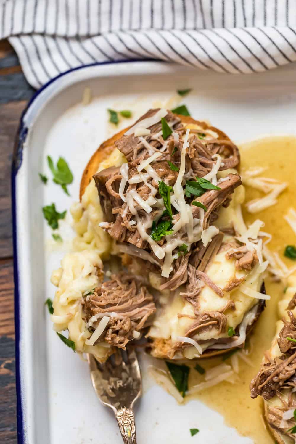 An Open-Faced Roast Beef Sandwich garnished with fresh herbs.