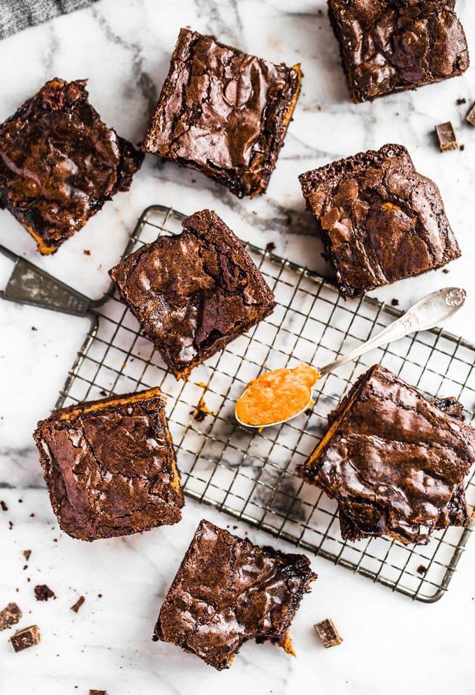 Perfect pumpkin brownies arranged around a cooling rack, with a spoonful of pumpkin