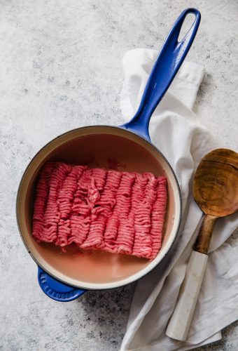Cook ground beef using a wooden spoon.