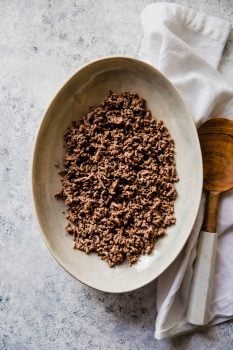 Cook ground beef with a wooden spoon.