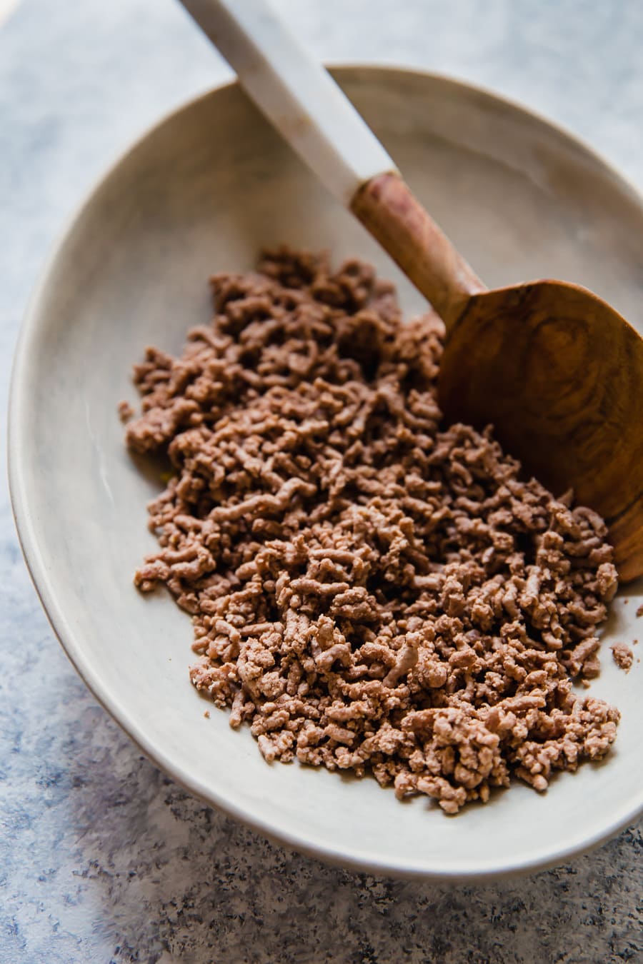 boiled ground beef in a bowl with a wooden spoon