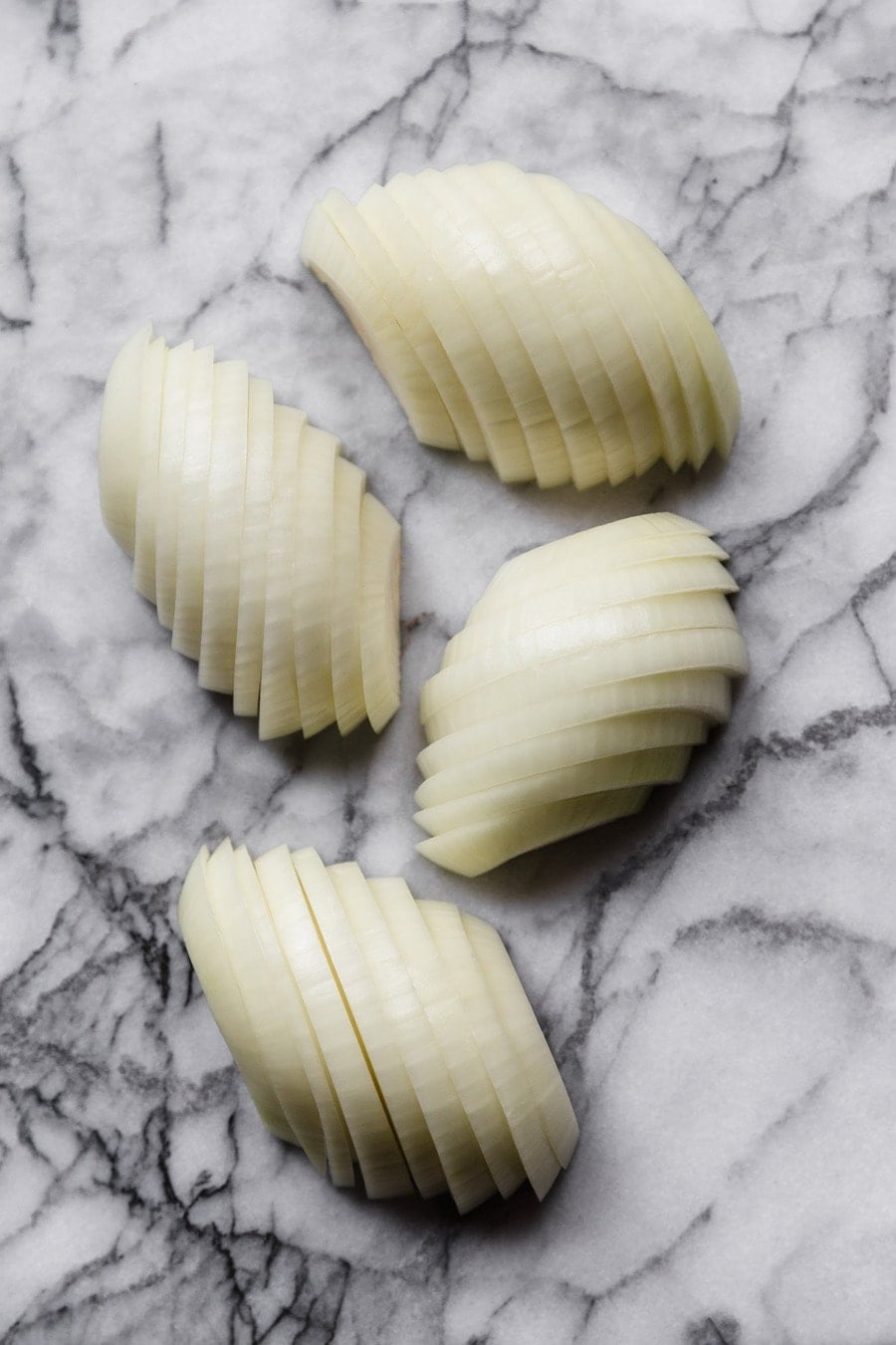 sliced onions on a marble surface