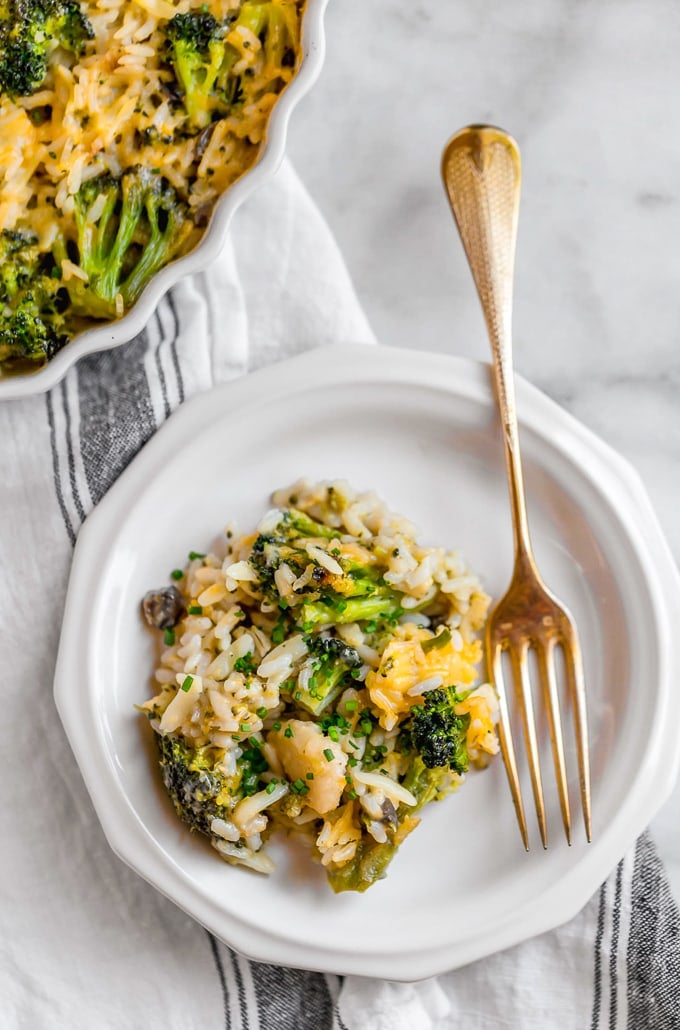 A plate of broccoli rice and cheese casserole with a gold fork
