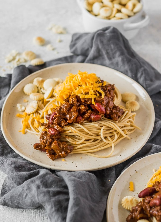 Cincinnati Style Chili topped with cheddar cheese on white plate