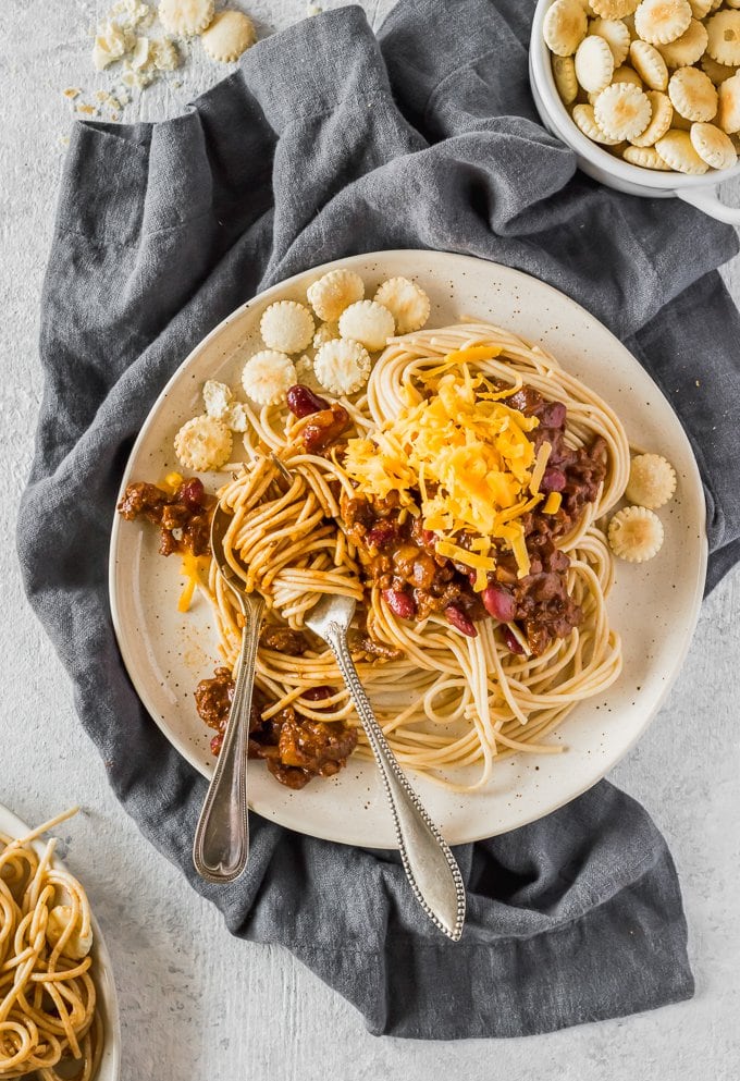 plate of chili spaghetti on blue towel with oyster crackers