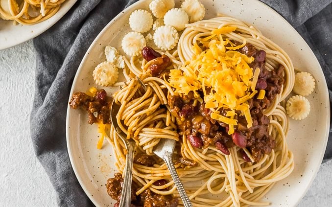 Cincinnati Chili is a delicious and unique Chili recipe atop spaghetti noodles and loaded with oyster crackers, cheese, beans, on onions. This Cincinnati Chili Recipe is both savory and sweet in all the right ways. This Cincinnati Style Chili is a must make for any Chili lover! 