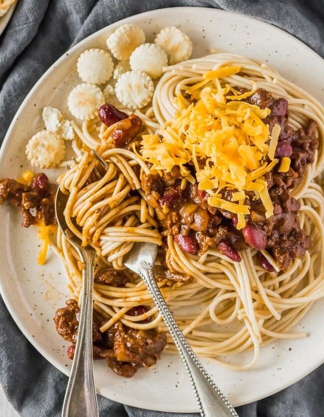 Cincinnati Chili is a delicious and unique Chili recipe atop spaghetti noodles and loaded with oyster crackers, cheese, beans, on onions. This Cincinnati Chili Recipe is both savory and sweet in all the right ways. This Cincinnati Style Chili is a must make for any Chili lover! 