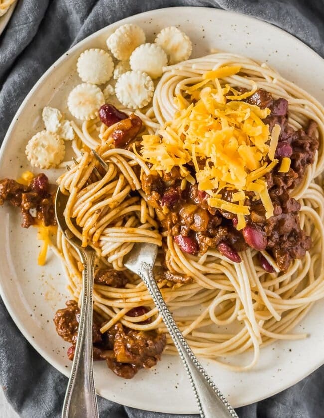 Cincinnati Chili is a delicious and unique Chili recipe atop spaghetti noodles and loaded with oyster crackers, cheese, beans, on onions. This Cincinnati Chili Recipe is both savory and sweet in all the right ways. This Cincinnati Style Chili is a must make for any Chili lover! 