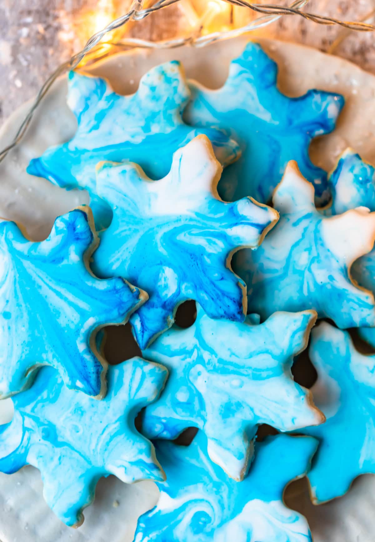 close up of a plate of Christmas butter cookies with blue marbled frosting