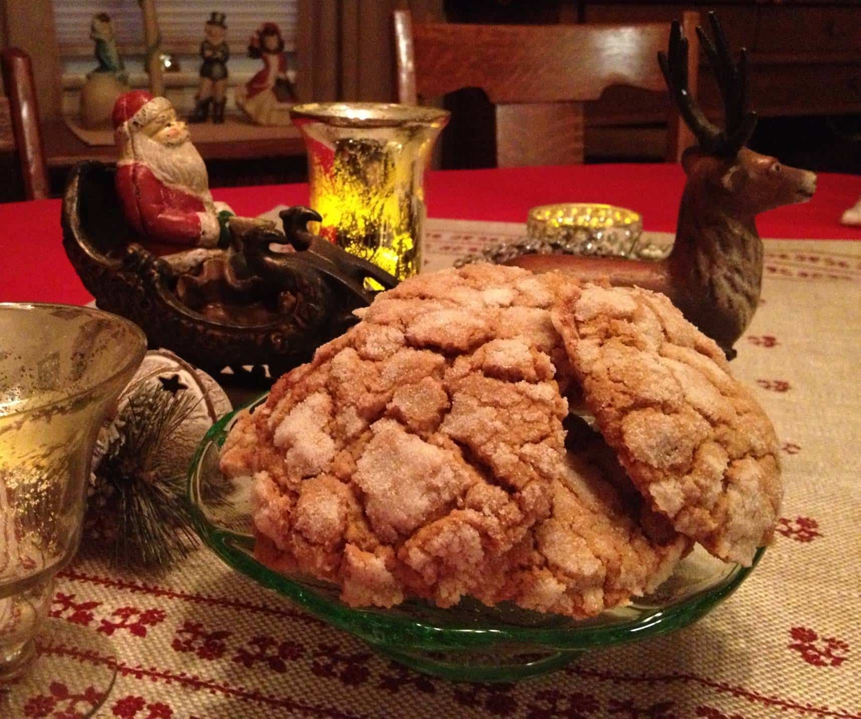 Ginger cookies on a glass plate, surrounded by Christmas decorations