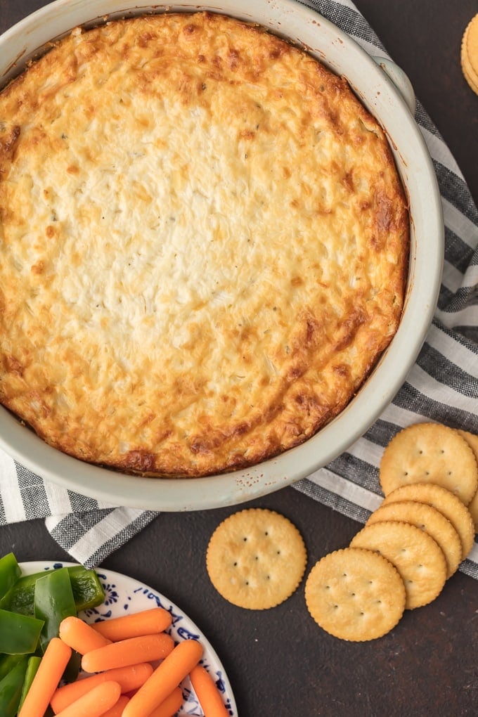 HOT ONION DIP has been a family favorite for years. I just love the sweet, cheesy onion flavor. You really can't do better than a classic hot onion dip recipe for the holidays or game day. It's perfect for dipping and oh so yummy. This is the BEST hot onion souffle dip recipe around! Hot Onion Dip in large white bowl
