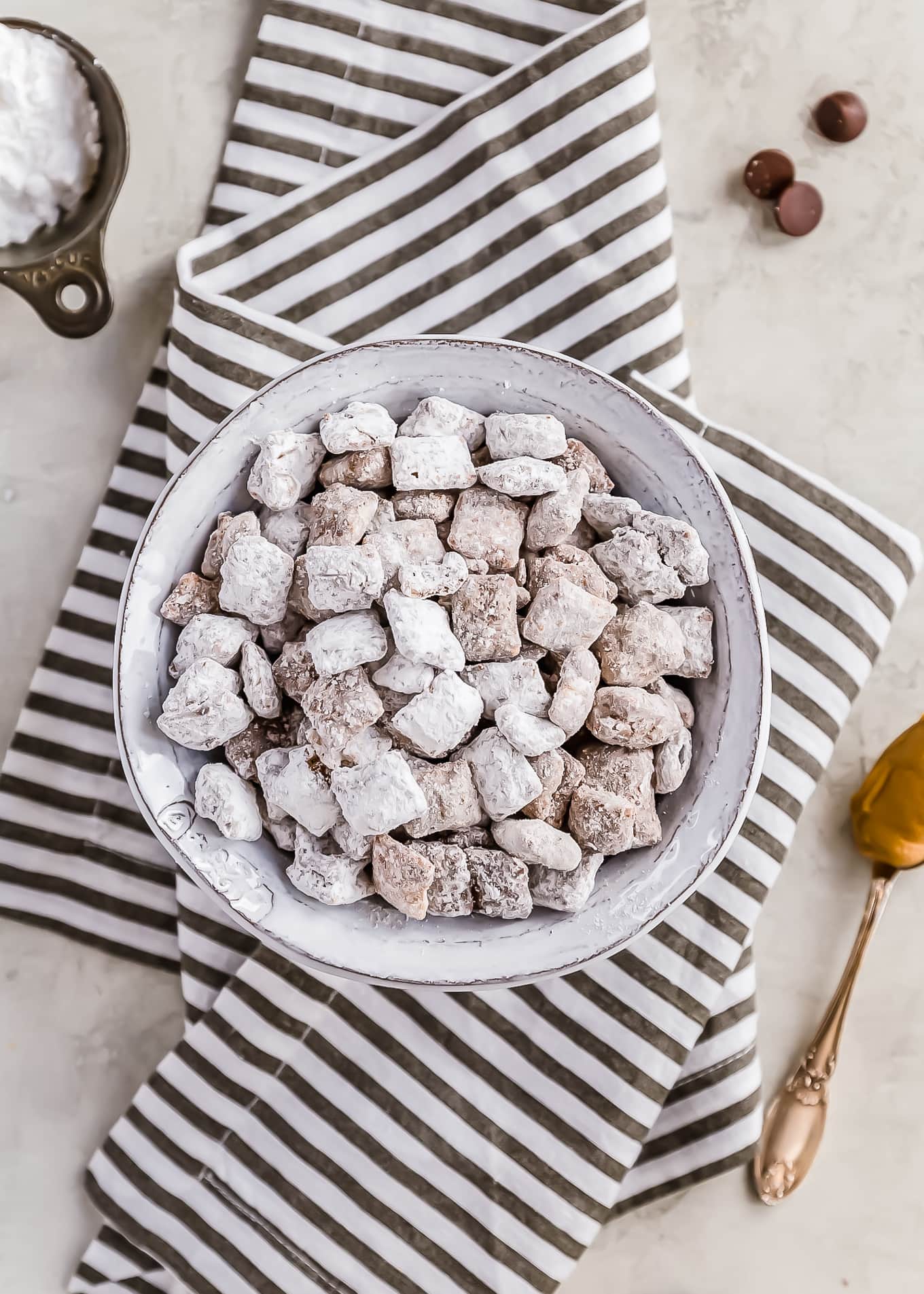 a bowl of puppy chow sitting on a striped dish towel