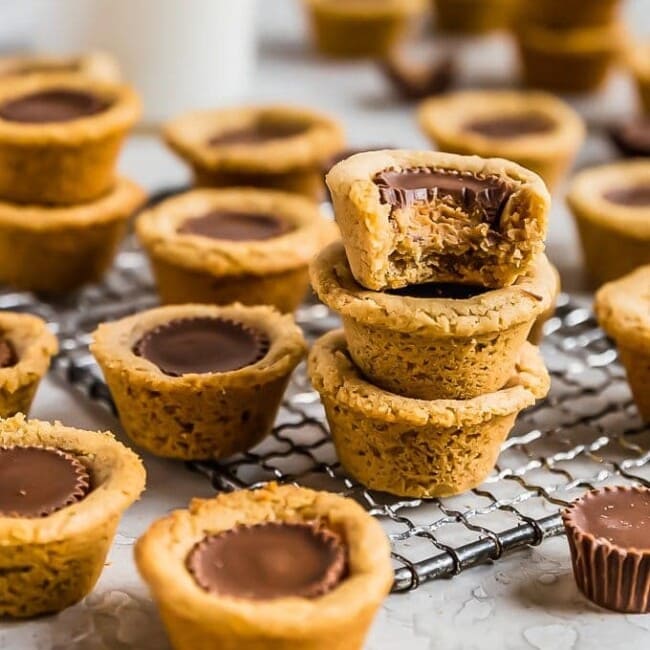Peanut Butter Cup Cookies are the perfect little treat. Mini peanut butter cups are baked right into tart shaped cookies for a delicious bite-sized dessert. Everyone will eat these Reese's Cup Cookies right up because no one can resist chocolate peanut butter cookies!