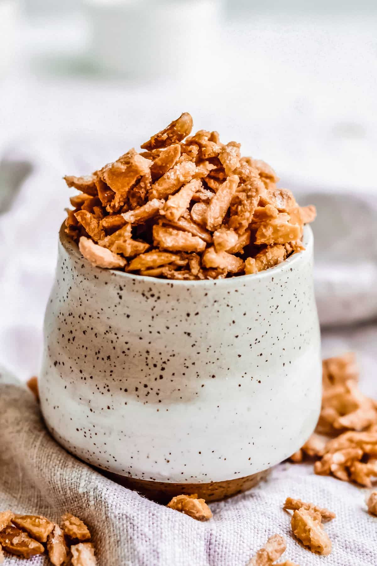 A ceramic cup filled with almonds