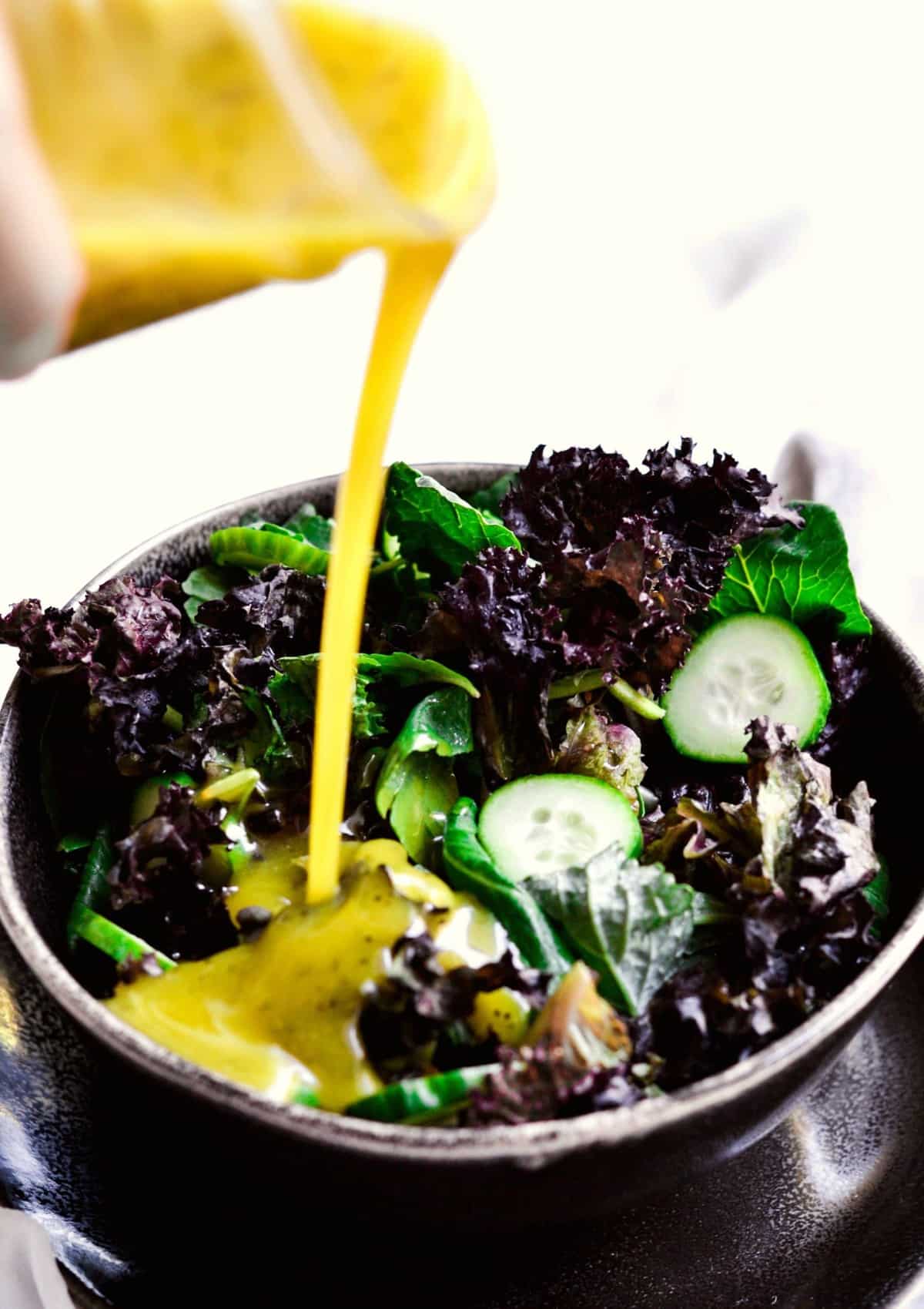 Pouring Sweet and Sour Dressing over a salad