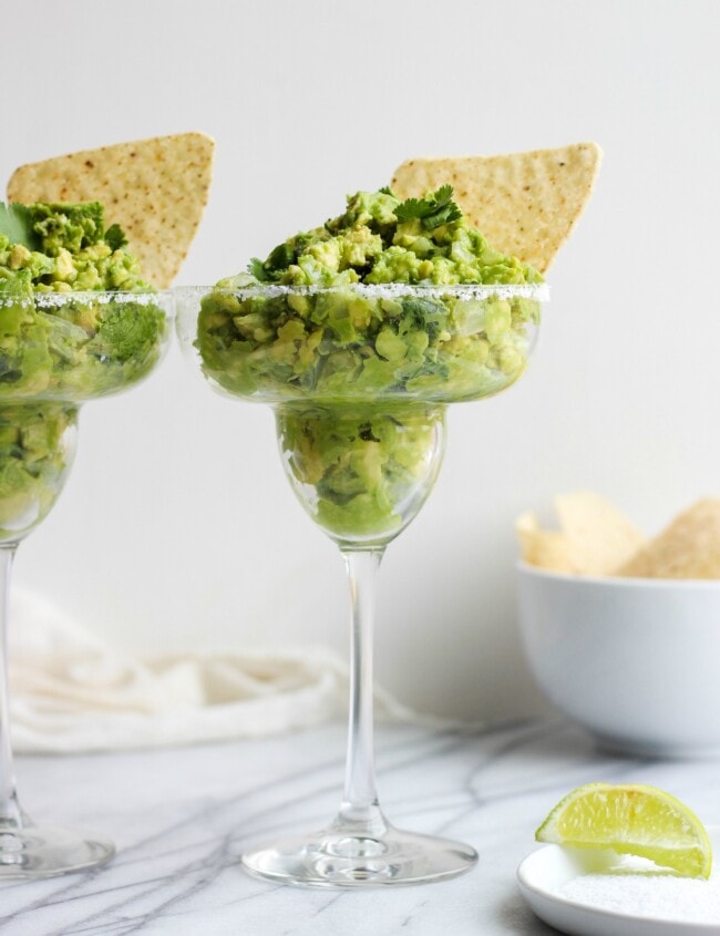 Guacamole Dip is a staple for game day, Cinco de Mayo, and summer parties. This delicious Margarita Guacamole Dip recipe is the perfect party dip, and it's so easy to make too. The secret? A bit of tequila mixed into the guacamole for an extra kick!