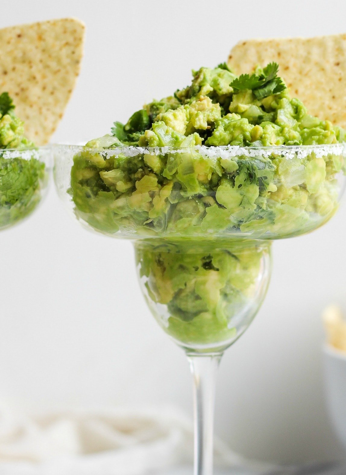 close up on a margarita glass filled with guacamole dip