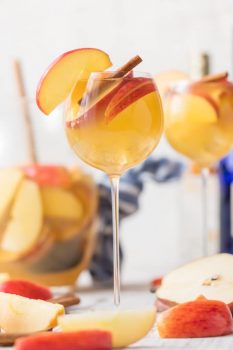 Apple Pie Sangria is a light, refreshing, delicious, and EASY Caramel Apple Sangria! This Fall Sangria Recipe is the hit of every party I take it to! Apple Pie Sangria is loaded with Apple Cider, Caramel Vodka, White Wine, Ginger Ale, and more! We call this Thanksgiving Sangria because it's Autumn in a glass. We have sangria recipes for every occasion, but this one is our favorite.