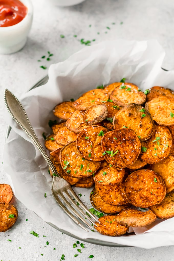 Sweet potato chips are a great healthy side dish that can go with just about anything! They are so easy and so much better than store-bought (deep fried) chips. This Baked Sweet Potato Chips Recipe is a go to for a fun and delicious but HEALTHY side dish. These Sweet Potato Chips are coated with a delicious spice blend and then baked and not fried. If you've wondered how to make Sweet Potato Chips crispy and addicting, today is your day!