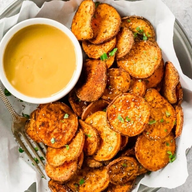 Sweet potato chips are a great healthy side dish that can go with just about anything! They are so easy and so much better than store-bought (deep fried) chips. This Baked Sweet Potato Chips Recipe is a go to for a fun and delicious but HEALTHY side dish. These Sweet Potato Chips are coated with a delicious spice blend and then baked and not fried. If you've wondered how to make Sweet Potato Chips crispy and addicting, today is your day!