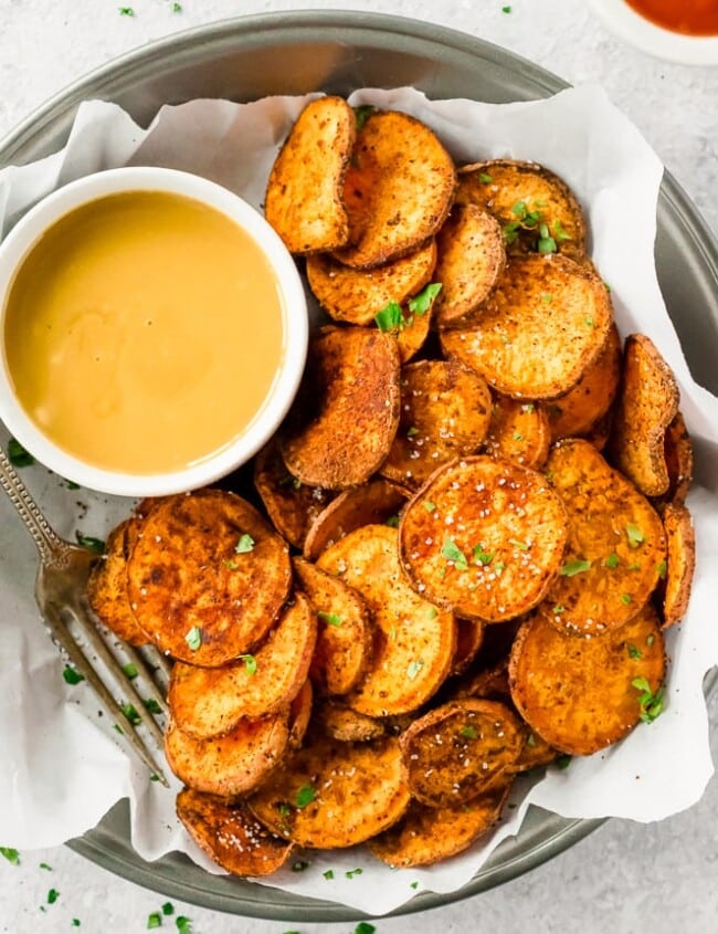 Sweet potato chips are a great healthy side dish that can go with just about anything! They are so easy and so much better than store-bought (deep fried) chips. This Baked Sweet Potato Chips Recipe is a go to for a fun and delicious but HEALTHY side dish. These Sweet Potato Chips are coated with a delicious spice blend and then baked and not fried. If you've wondered how to make Sweet Potato Chips crispy and addicting, today is your day!