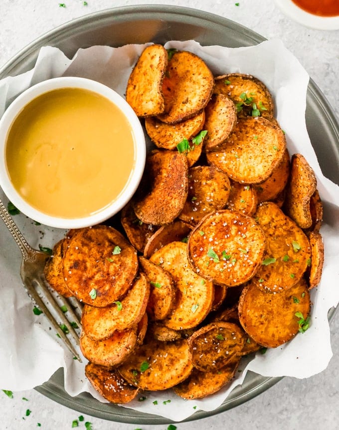sweet potato chips on a plate with dipping sauce