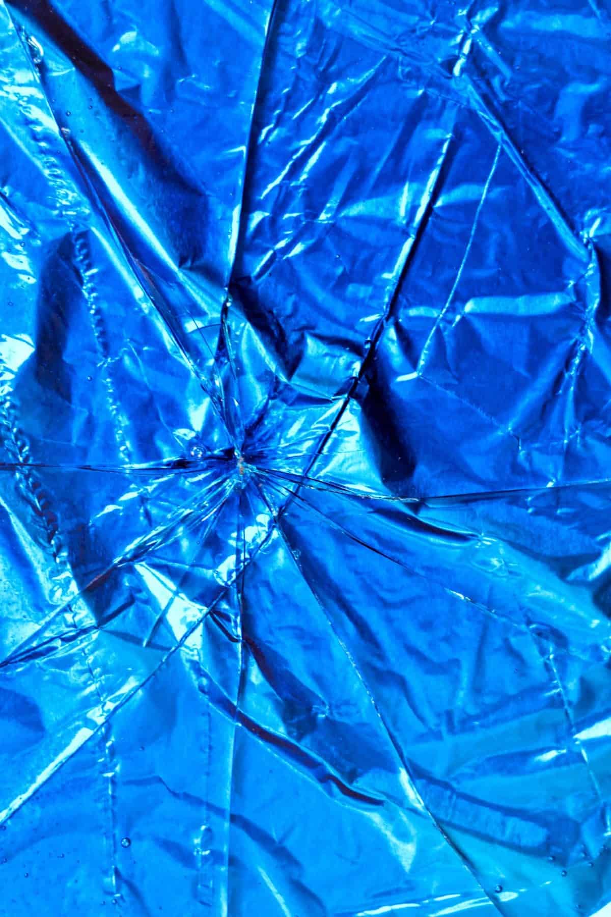 Image of sheet of blue rock candy with several cracks in it.