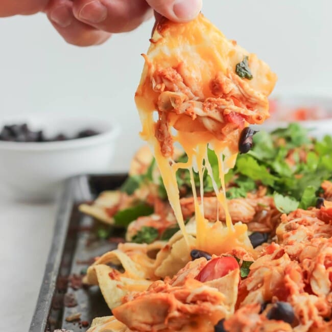 Grilled Chicken Nachos are a delicious and fun way to use your grill, even in the chillier months. Piled high with cheese and favorite toppings, the grilled smokey flavor will really surprise you! Choose from 2 flavors: BBQ Chicken Nachos or Mexican Nachos.