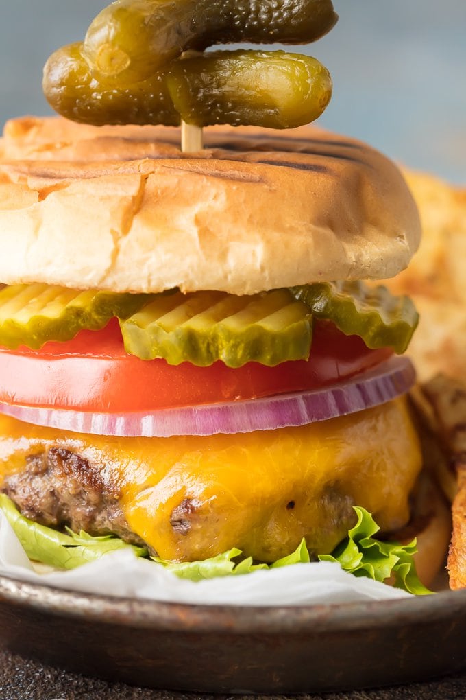 Stovetop Burgers are easier than you might think! Once we learned How to Cook Burgers on the Stove it's our go-to easy dinner for anytime of year. Cooking Burgers on the Stove is a great way to make sure you cook a JUICY and PERFECT Stovetop Burger each and every time. Hamburgers on the Stove is the only way to cook cheeseburgers! up close picture of the best burger recipe cooked on the stove