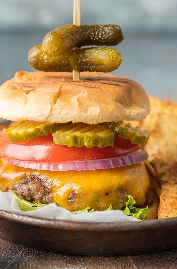 stovetop burgers topped with cheese, lettuce, tomato, onion, and pickles