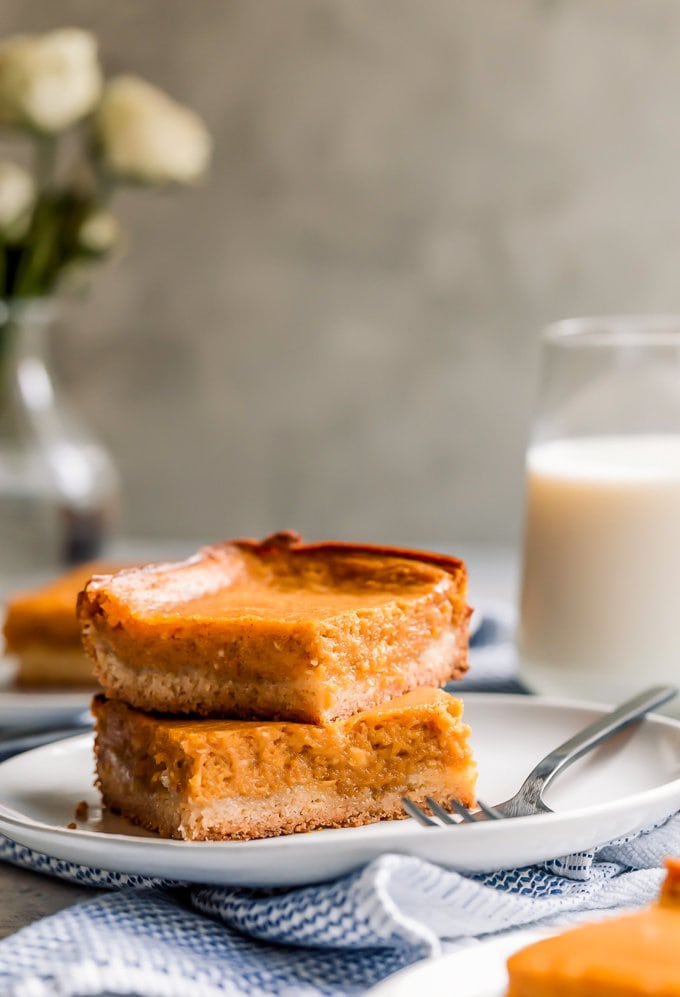 Two pumpkin gooey butter cake bars stacked on top of each other