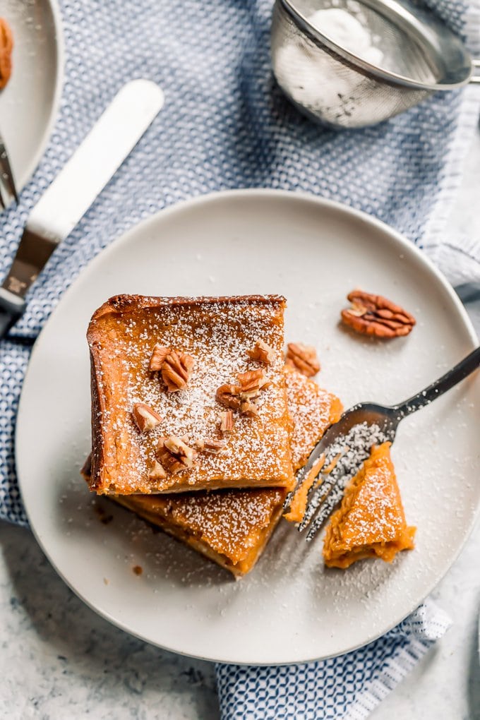 Pumpkin gooey butter cake topped with powdered sugar and pecans