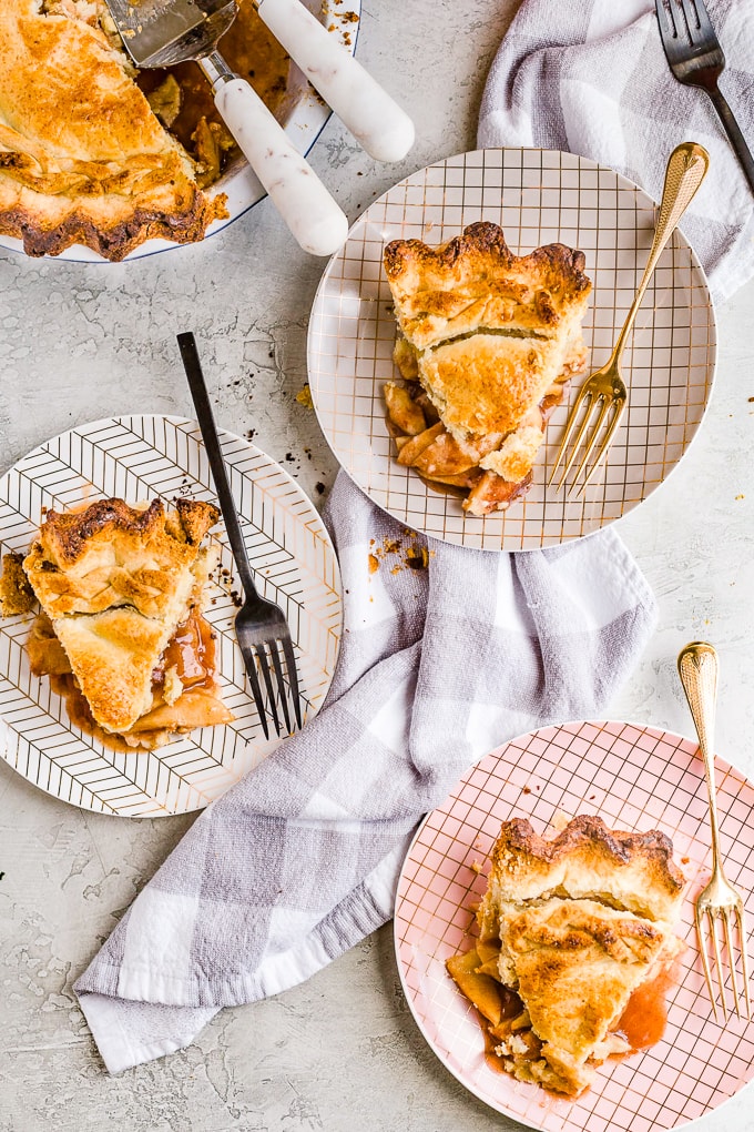 3 slices of homemade apple pie on small plates with forks