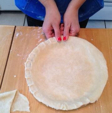 Photo showing how to use thumbs to crimp a homemade pie crust.