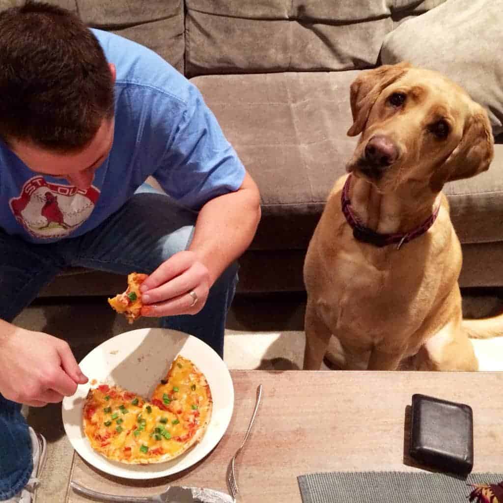 Photo of a man eating a Chicken Mexican Pizza.