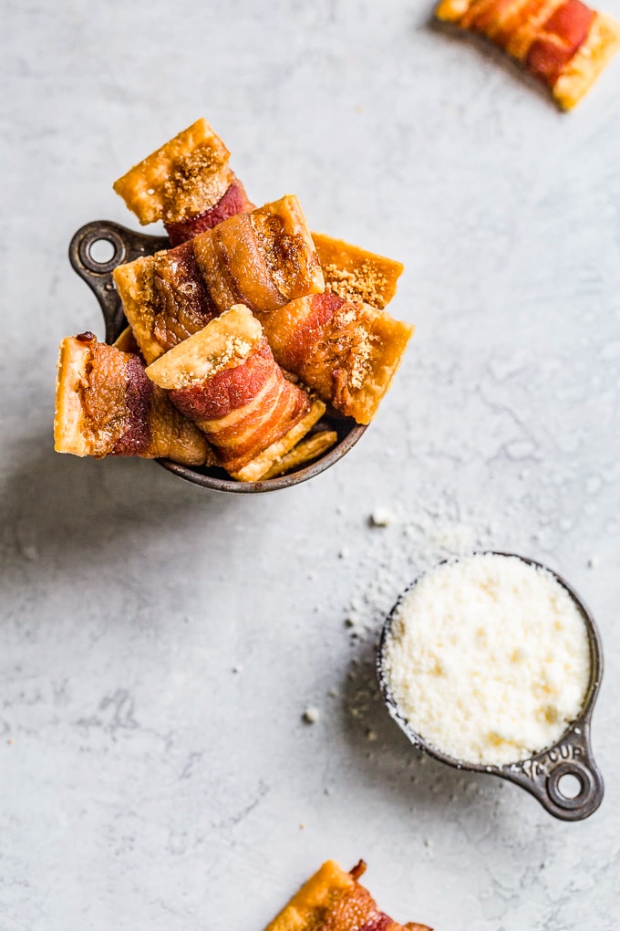 bacon crackers next to a measuring cup filled with grated cheese