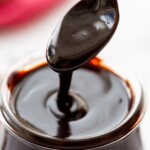 homemade hot fudge being spooned out of jar