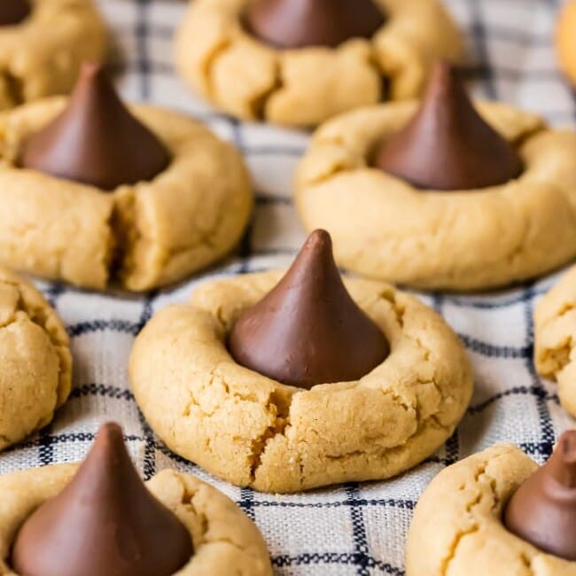 Peanut Butter Blossoms are a classic cookie recipe that is easy to make and loved by all! This BEST Peanut Butter Kiss Cookies Recipe has been in our family for years. Chocolate Peanut Butter Cookies are perfect for Christmas baking, but also made for enjoying year round, especially at Summer BBQs. When it comes to favorite cookie recipes, these Peanut Butter Hershey Kiss Cookies can't be beat. 