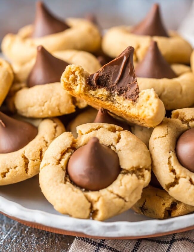 Peanut Butter Blossoms are a classic cookie recipe that is easy to make and loved by all! This BEST Peanut Butter Kiss Cookies Recipe has been in our family for years. Chocolate Peanut Butter Cookies are perfect for Christmas baking, but also made for enjoying year round, especially at Summer BBQs. When it comes to favorite cookie recipes, these Peanut Butter Hershey Kiss Cookies can't be beat. 