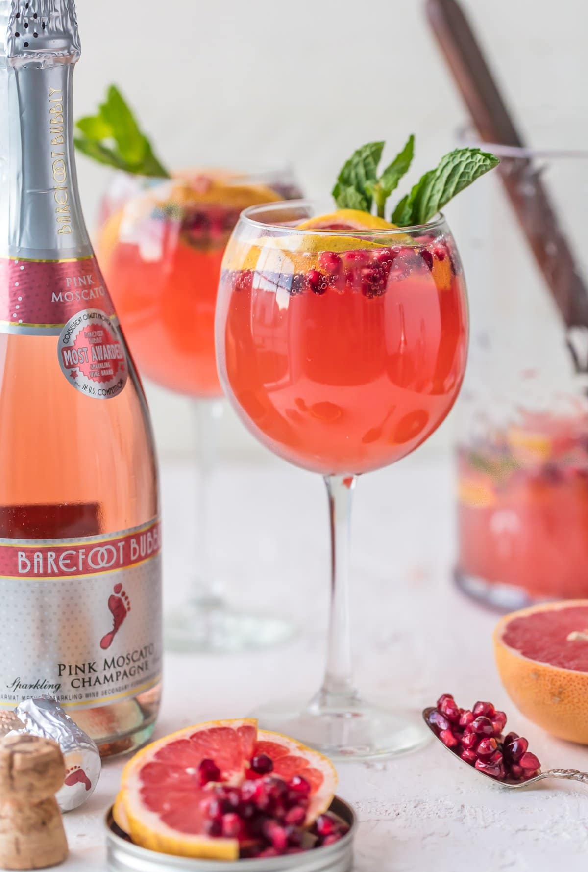 PINK CHAMPAGNE SANGRIA is the perfect New Years Eve cocktail! Ring in the new year with style, and lots of pink bubbly! Champagne mixed with grapefruit juice, pomegranate juice, and mint simple syrup, seriously delish!