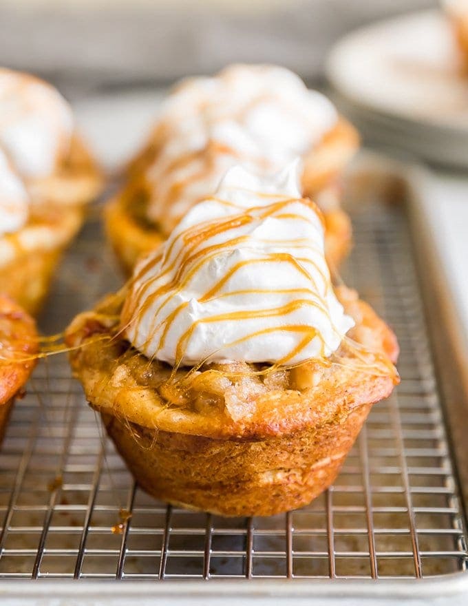 Apple Pie Cupcakes topped with cream and caramel syrup