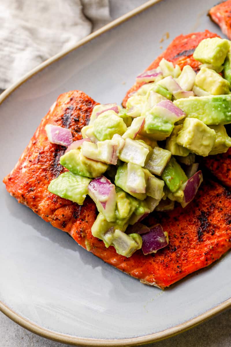 up close platter of grilled salmon with avocado salsa