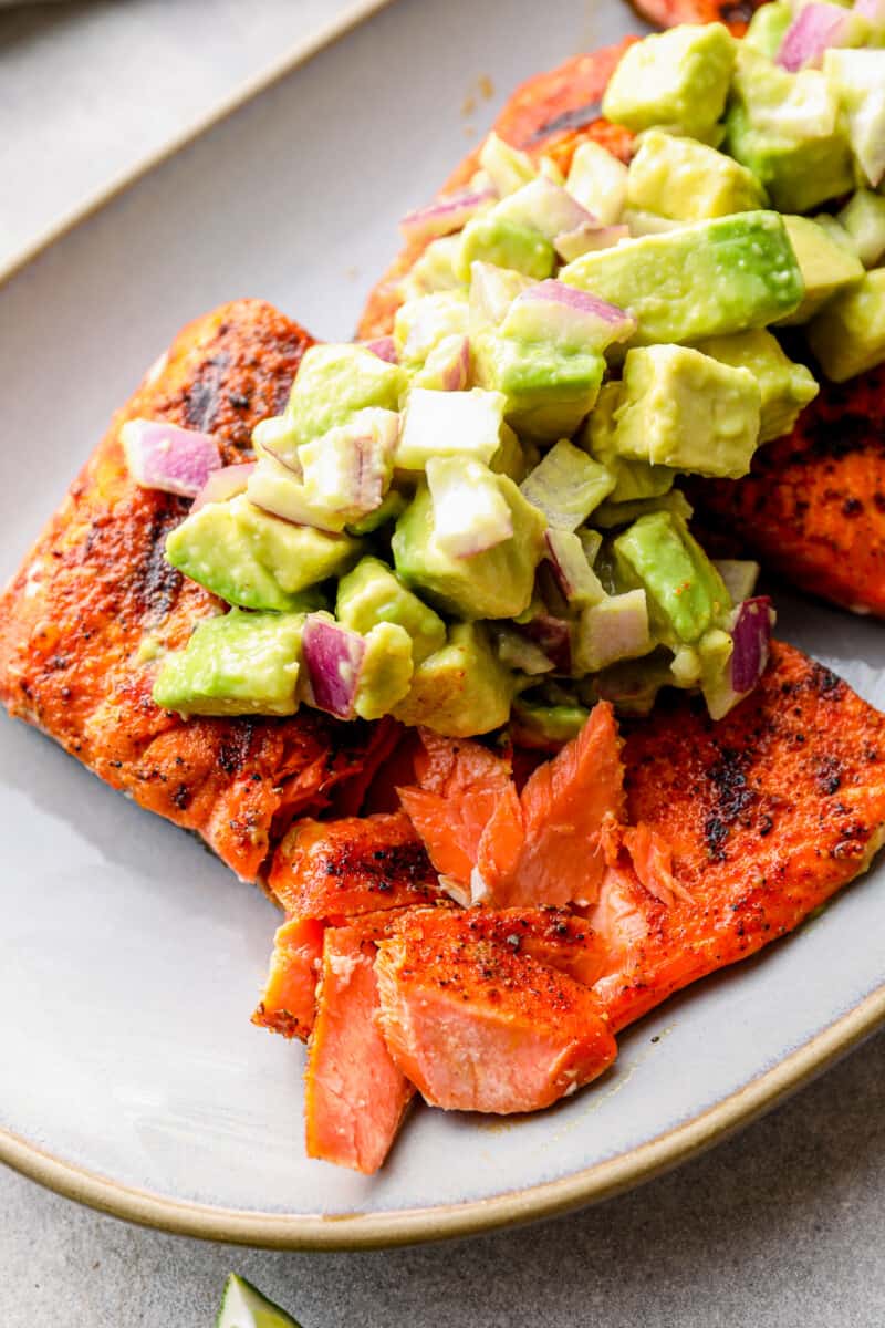 up close platter of grilled salmon with avocado salsa