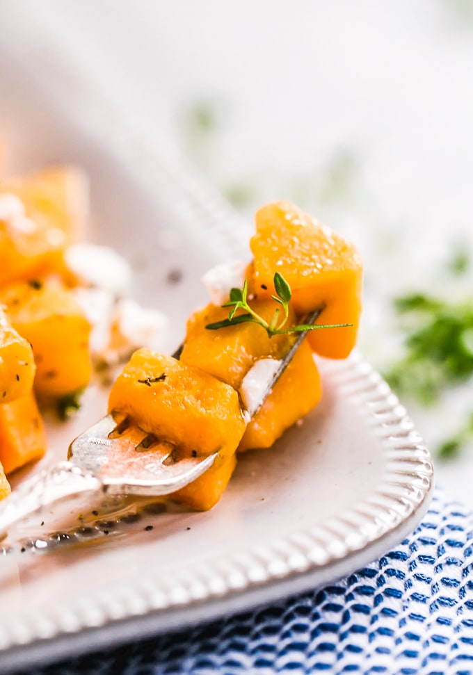 Baked Butternut Squash is such a simple side dish, but so delicious and healthy too. This maple-infused recipe is so sweet yet the broth balances it out perfectly. This maple roasted butternut squash recipe is easy to make, and you can also make a mashed version if you prefer. Pair it with your favorite main dish for dinner, or make this as the perfect Thanksgiving side dish! Maple Butternut Squash on a fork