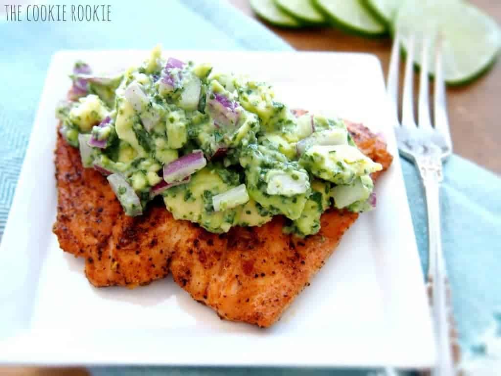 grilled salmon on a plate, topped with avocado salsa