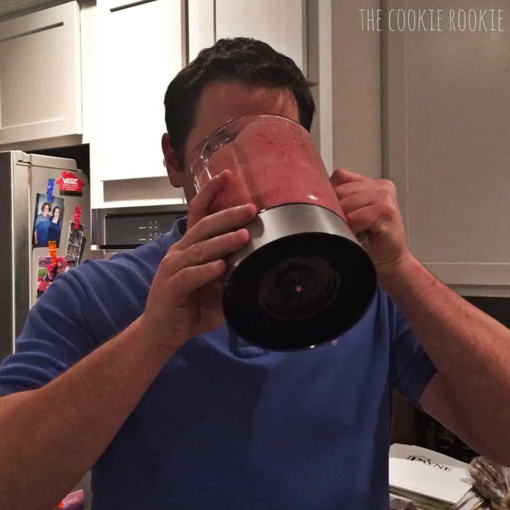 Man drinking from wine smoothies straight from the blender.